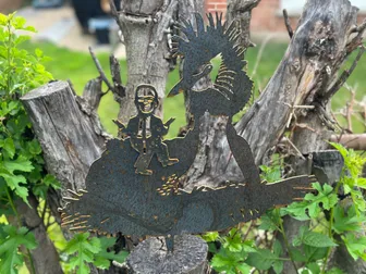 A metal John Oliver riding a metal pūteketeke